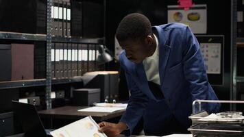 africano americano maschio investigatore analisi prova e conduce un' confidenziale indagine. nero uomo con competenza nel criminologia recensioni legale File e classificato ricerca informazione. foto