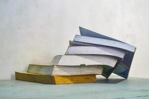 il mucchio di libri collassata su il tavolo raffigura il distruzione di formazione scolastica foto