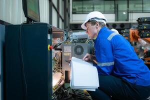 tecnico Lavorando su il elettrico controllo Consiglio dei ministri di robotica braccio, robotica braccia industriale sfondo foto