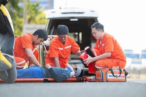 il paramedico è assistere un ferito uomo nel un emergenza situazione su il strada. foto