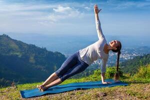 donna fare yoga asana vasisthasana lato tavola posa all'aperto foto