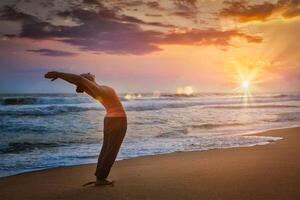 giovane sportivo in forma donna fare yoga sole saluto surya namaskar foto