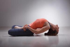 bellissimo sportivo in forma yogi ragazza pratiche yoga asana matsyasana foto