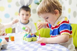 contento Pasqua. bambini tintura colorato uovo per Pasqua caccia foto