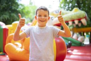 contento ragazzo avendo un' molte di divertimento su un' colorato gonfiare castello foto