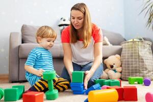 ragazzo e bambino sviluppo specialista giocando insieme con colorato blocchi foto
