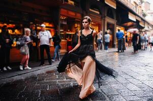 un' bellissimo elegante sposa nel un' nero vestito passeggiate attraverso Firenze, un' modello nel un' nero vestito nel il vecchio città di Italia foto