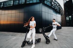 un' ragazza e un' tipo siamo a piedi su elettrico scooter in giro il città, un' coppia nel amore su scooter. foto