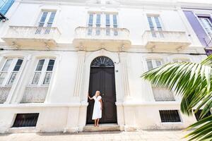 tenerife, canarino isole, Spagna. un' ragazza nel un' bianca vestito sta contro il parete di un' Casa nel Santa Cruz de tenerife. foto