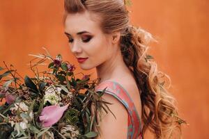 un' giovane modello ragazza nel un' bellissimo vestito con un' mazzo di fiori nel il campagna nel Francia. ragazza con fiori nel il primavera provence villaggio. foto