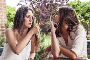 Due giovane femmina amici avendo divertimento cantando un' nuovo canzone foto