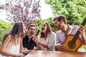 gruppo di giovane amici avendo divertimento cantando un' canzone foto