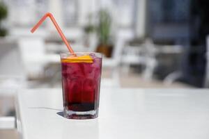 rosa e rosso fresco colorato esotico alcolizzato cocktail con Limone e ghiaccio su ristorante tavolo. colorato rosa morbido bevanda con ghiaccio foto