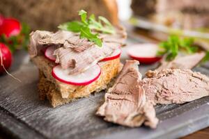 Sandwich con al forno carne, ravanello e erbe aromatiche foto