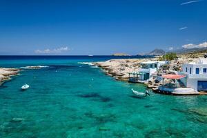 piccolo porto con pesca Barche nel chiaro acqua, imbiancato Casa. mitakas villaggio, milos isola, Grecia. foto