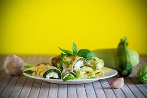 cucinato zucchine rotoli con formaggio Riempimento dentro, nel un' piatto foto