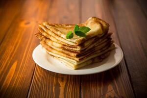 lotto di Pancakes magro Pancakes nel un' piatto, su di legno tavolo. foto