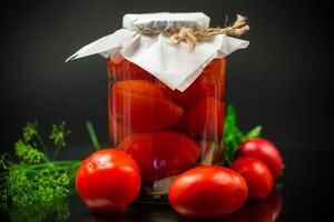 in scatola maturo rosso pomodori con spezie nel un' grande bicchiere barattolo. foto