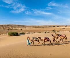 Due cammellieri con cammelli nel dune di thar deser foto