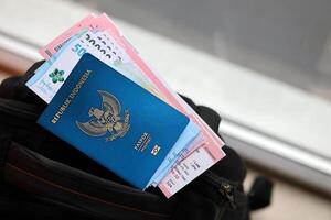 blu repubblica Indonesia passaporto con i soldi e linea aerea Biglietti su turistico zaino foto