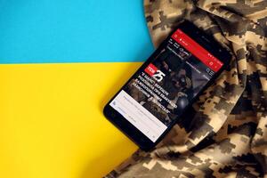 kiev, Ucraina - 4 Maggio, 2023 tsn ucraino notizia portale su smartphone schermo con ucraino bandiera e camuffare tessuto foto