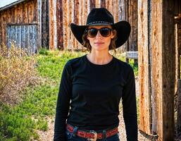 ai generato foto di bellissimo donna come un' professionale agente indossare nero lungo manica camicia e tattico ansimare e cowboy cappello om ranch, generativo ai
