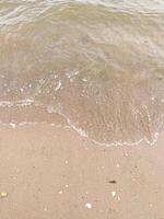 morbida onda dell'oceano blu sulla spiaggia sabbiosa. sfondo. foto