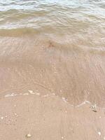 morbida onda dell'oceano blu sulla spiaggia sabbiosa. sfondo. foto