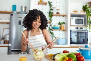 giovane donna preparazione verdura insalata nel sua cucina. salutare stile di vita concetto bellissimo donna con misto verdura. foto