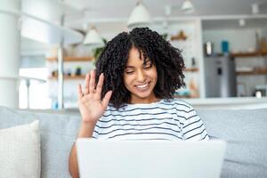 giovane donna agitando a il computer portatile e parlando per sua amici attraverso video chiamata, donna alunno parlando di video conferenza chiamata, femmina insegnante allenatore tutoraggio di webcam, in linea addestramento, e-coaching concetto foto