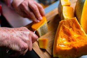 taglio un' zucca nel il cucina per cucinando e congelamento foto