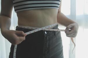 donne corpo Grasso gonfiarsi. obeso donna mano Tenere eccessivo pancia Grasso. dieta stile di vita concetto per ridurre pancia e forma su salutare stomaco muscolo. foto