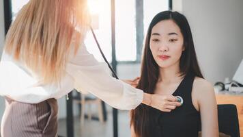 un' assistenza sanitaria professionale conduce un' routine stetoscopio verifica su un dipendente nel un' soleggiato, contemporaneo ufficio ambiente. foto