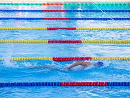 un' giovane uomo nuoto nel un all'aperto piscina. avvicinamento foto. concetto di sport e assistenza sanitaria foto