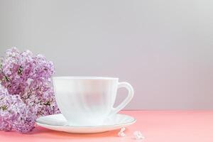 tazza di caffè e lilla fiori su leggero sfondo. foto