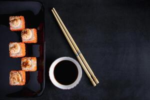 impostato di Sushi rotolo su nero piatto. servendo giapponese cibo nel ristorante. foto