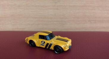 miniatura giallo auto giocattolo su rosso sfondo con copia spazio per testo foto