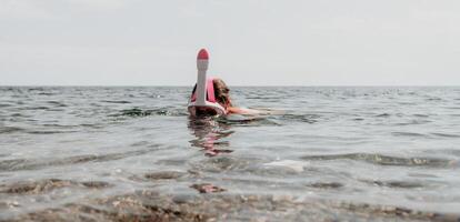 giovane contento donna nel bianca bikini e indossare rosa maschera prende pronto per mare snorkeling. positivo sorridente donna rilassante e godendo acqua attività con famiglia estate viaggio vacanze vacanza su mare. foto