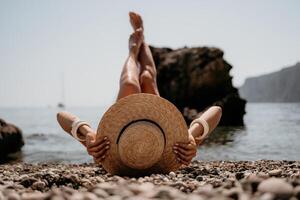 donna viaggio mare. contento turista nel cappello godere assunzione immagine all'aperto per ricordi. donna viaggiatore in posa su il spiaggia a mare circondato di vulcanico montagne, condivisione viaggio avventura viaggio foto