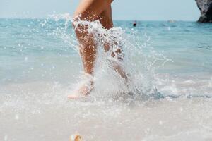 mare spiaggia viaggio - donna a piedi su sabbia spiaggia in partenza impronte nel il bianca sabbia. femmina gambe a piedi lungo il mare a piedi nudi, avvicinamento di il abbronzato gambe di un' ragazza In arrivo su di il acqua. foto