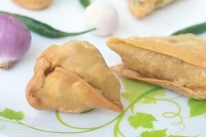 un' samosa è un' fritta Pasticcino a partire dal Sud Asia quello è pieno con salato ingredienti Compreso piselli, Maiale, pesce, cipolle, o speziato patate. anche chiamato Shingara. foto