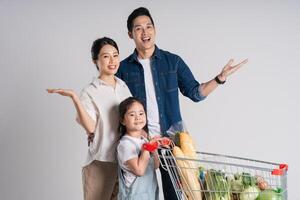 Immagine di asiatico famiglia spingendo un' supermercato carrello mentre acquisti, isolato su bianca sfondo foto