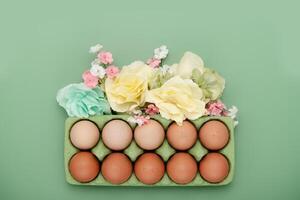 verde scatola di cartone di uova con fiore corona. Pasqua sfondo foto