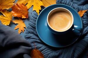 ai generato accogliente autunno, blu caffè boccale su caldo a maglia tessuto con giallo caduto autunno le foglie foto