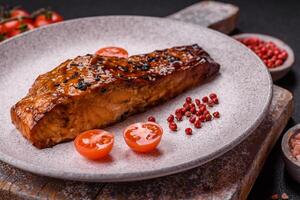 delizioso rosso salmone pesce grigliato con salsa e sesamo, spezie e erbe aromatiche foto