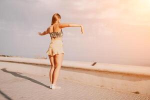 donna estate danza. silhouette di un' contento donna chi balli, gira e solleva sua mani per il cielo. un' giocoso giovane donna gode sua contento momento danza nel il raggi di il d'oro sole. foto