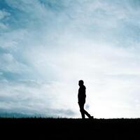 uomo silhouette nel il campagna nel il estate e tramonto sfondo foto