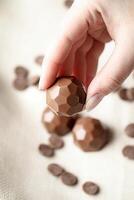 persona Tenere un' cioccolato palla nel loro mano foto