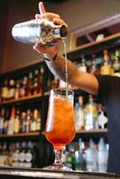 barista scrosciante un' cocktail in un' arginato bicchiere foto