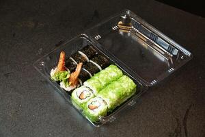 plastica contenitore pieno con Sushi e verdure foto